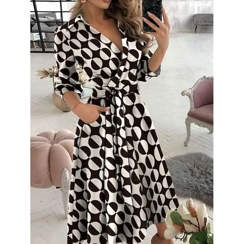 Woman wearing a black and white patterned dress in a room with furniture.